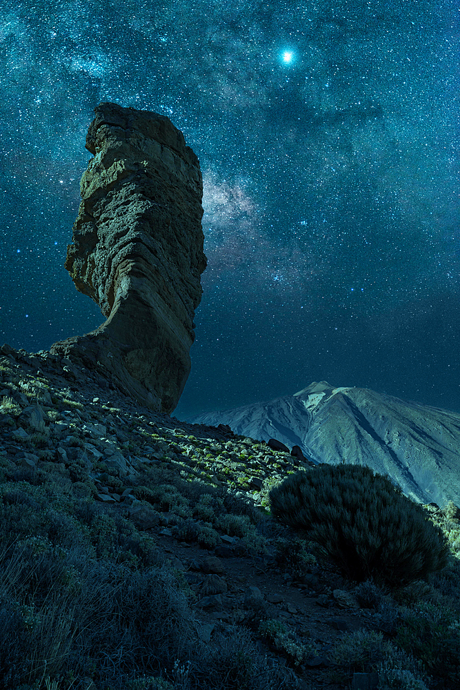 Milky way on the Roque Cinchado next to Teide in the natural park of Tenerife, Canary Islands. Spain