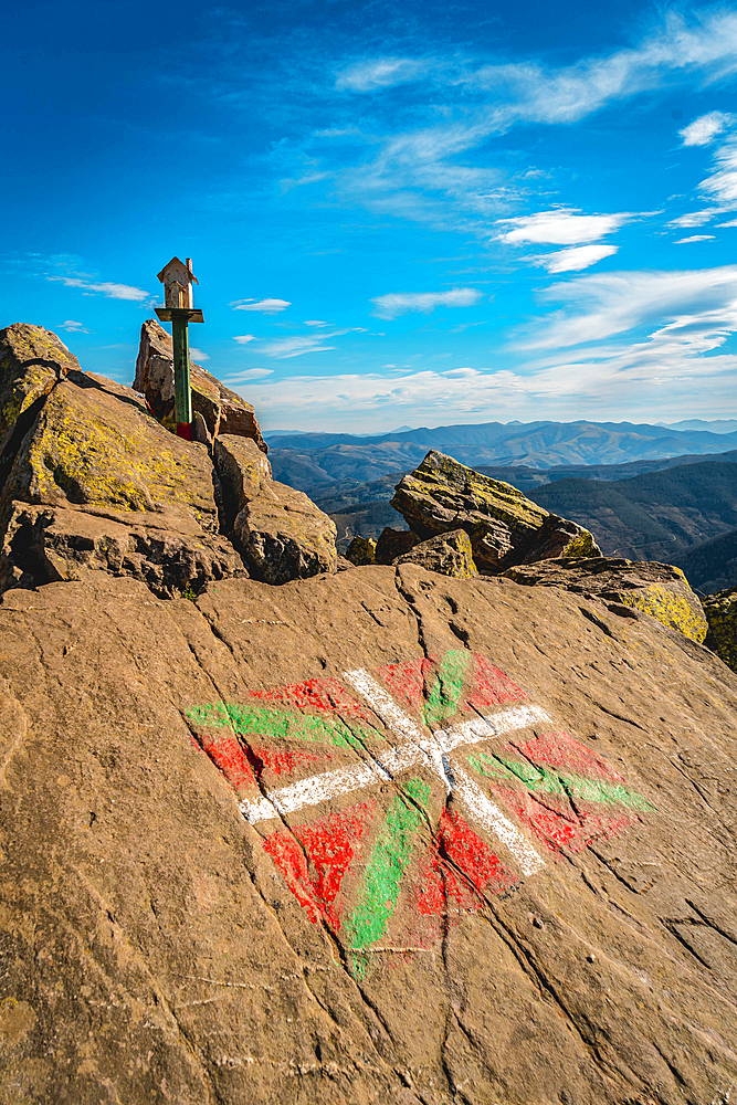 The flag of the Basque country and a figure of a house above Mount Adarra in Guipuzcoa one winter morning