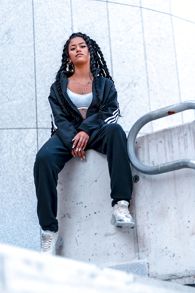 Urban session. Young woman of black ethnicity with long braids and with tattoos