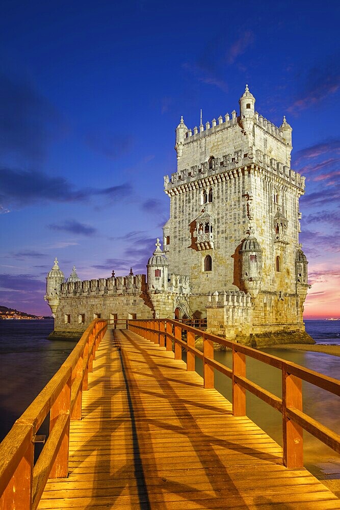 Belem Tower or Tower of St Vincent, famous tourist landmark of Lisboa and tourism attraction, on the bank of the Tagus River (Tejo) after sunset in dusk twilight with dramatic sky. Lisbon, Portugal, Europe