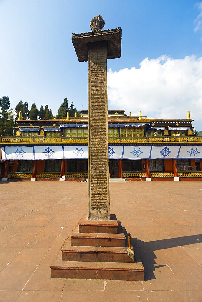 The inscribed pillar at the center of the Rumtek Monastery courtyard details the history of the monastery located in Gangtok, Sikkim, India, Asia