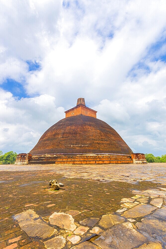 Jetavanaramaya Dagoba or stupa with damaged spire seen centred from platform corner in the ancient capitol of Anuradhapura Kingdom on a beautiful blue sky day in Sri Lanka