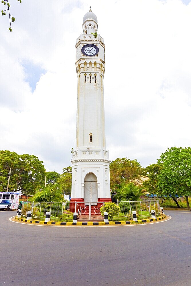 Jaffna, Sri Lanka, February 3, 2015: Bus driving around a British colonial style roundabout at the central landmark clock tower on an overcast day in downtown, Asia