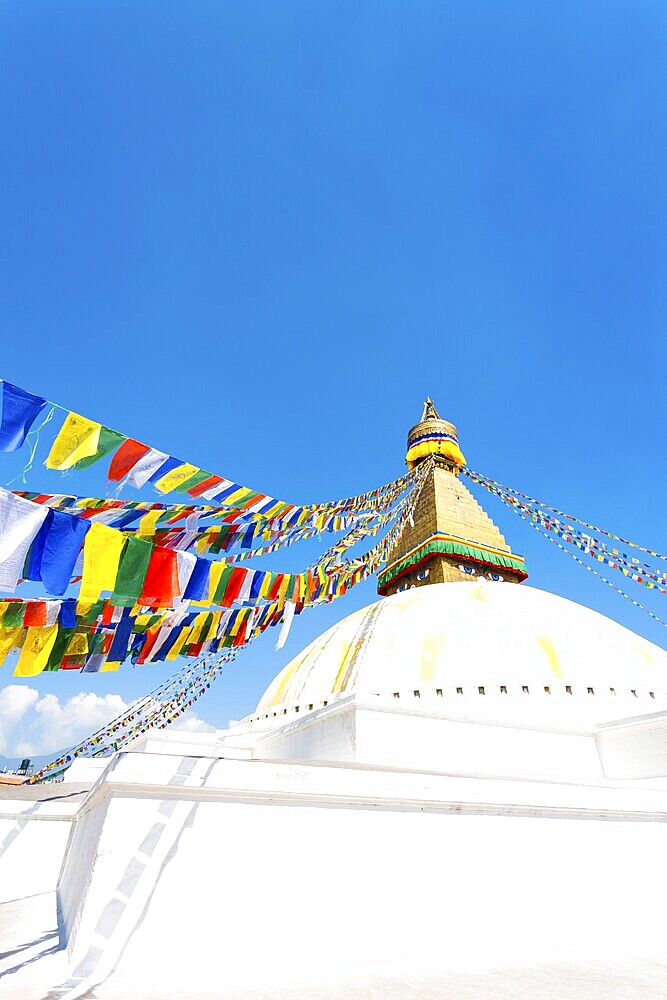 Prayer flags on white second level of Boudhanath Stupa in Kathmandu, Nepal on October 23, 2013. Vertical