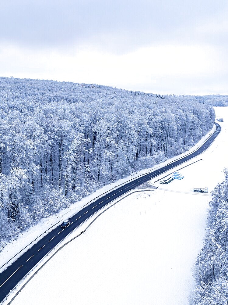 A long road runs through the wintry landscape, captured from above, Black Forest, aerial view, Gechingen, Germany, Europe