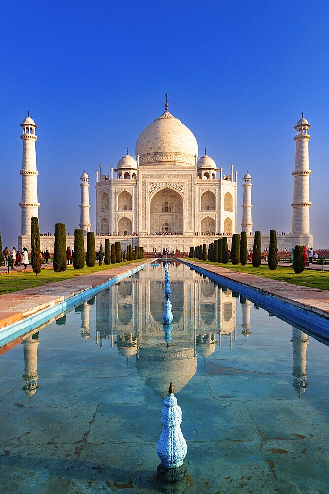 Symmetrical view of the Taj Mahal with its reflection in the water under a clear blue sky, Taj Mahal, Agra, India, Asia