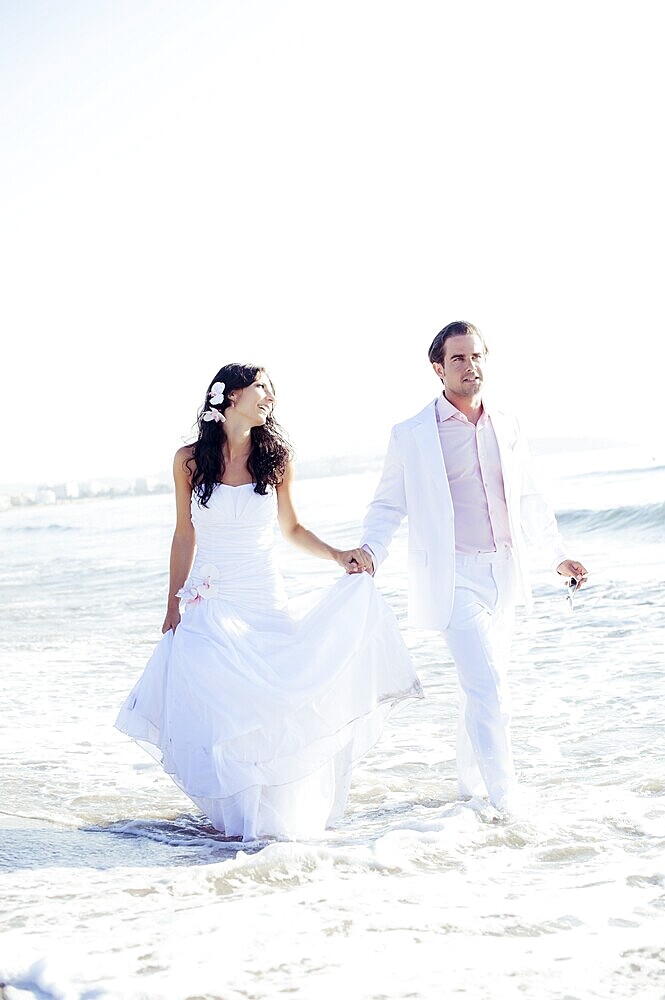 Bride and groom walking on the beach, Ibiza, Spain, Europe