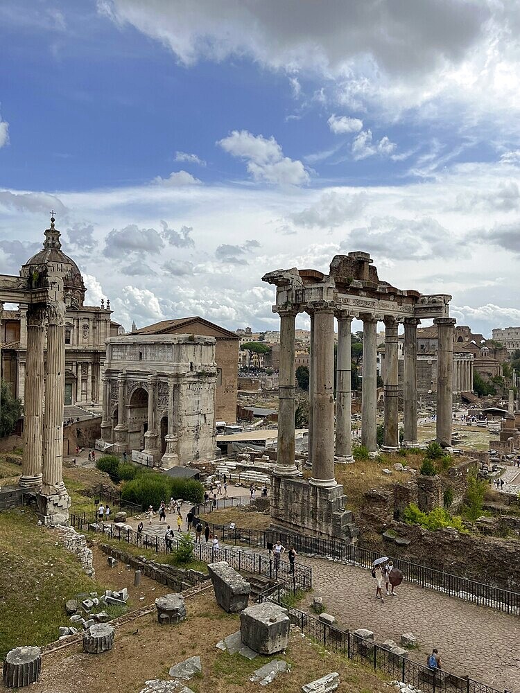 View of ancient ruins and temples with impressive columns under a cloudy sky, Rome, Italy
