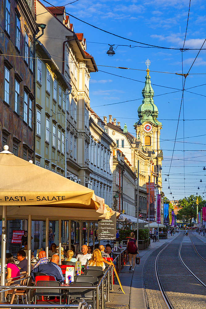 View of Parish Church of the Holy Blood and cafes, Graz, Styria, Austria. Europe