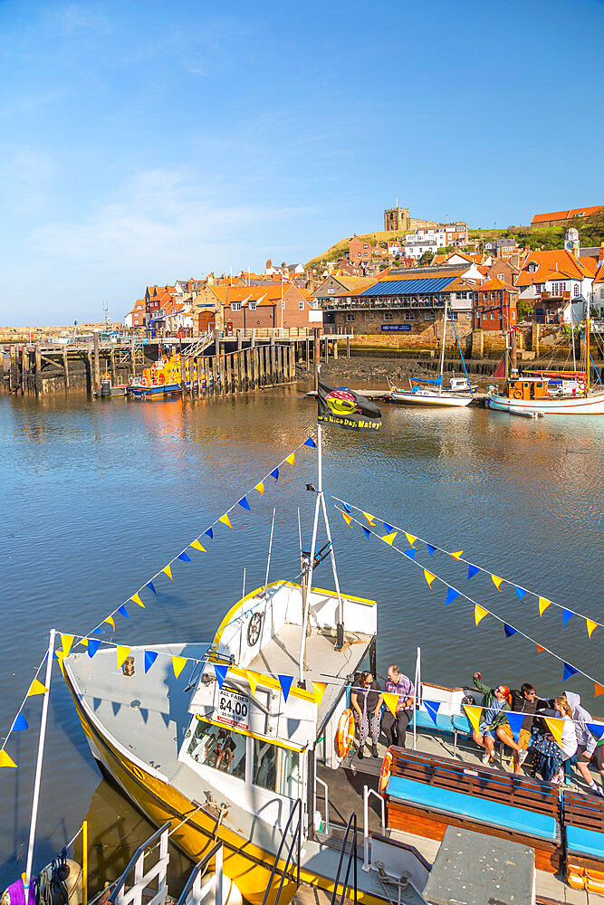 View of St. Mary's Church and restaurants, houses and boats on the River Esk, Whitby, Yorkshire, England, United Kingdom, Europe