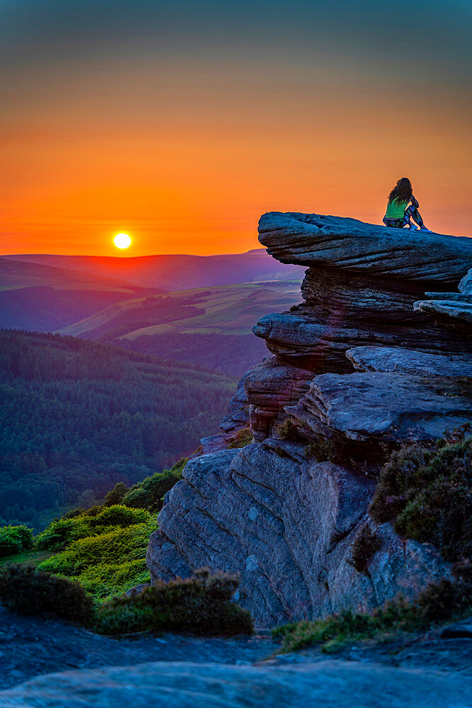 View of young woman on Bamford Edge at sunset, Bamford, Peak District National Park, Derbyshire, England, United Kingdom, Europe