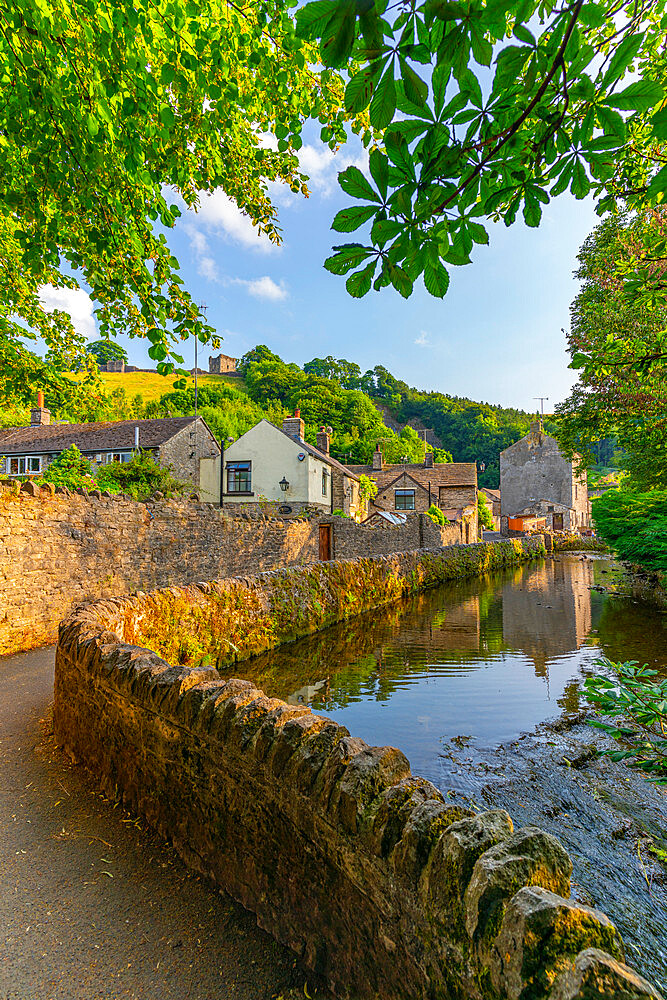 View of Castleton village and stream overlooked by Peveril Castle, Hope Valley, Peak District National Park, Derbyshire, England, United Kingdom, Europe