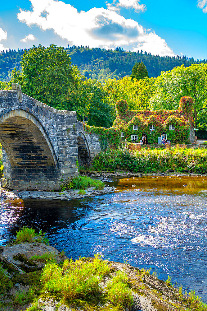 View of Pont Fawr (Inigo Jones Bridge) over Conwy River and cafe, Llanrwst, Clwyd, Snowdonia, North Wales, United Kingdom, Europe