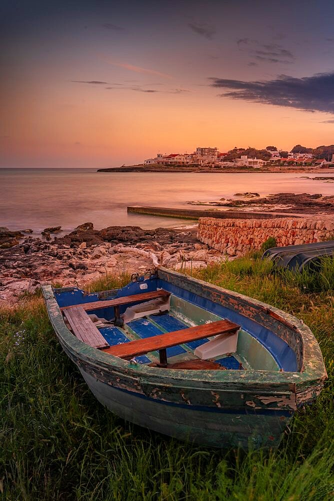 View of Playa Punta Prima and rowing boat at dusk, Punta Prima, Menorca, Balearic Islands, Spain, Europe