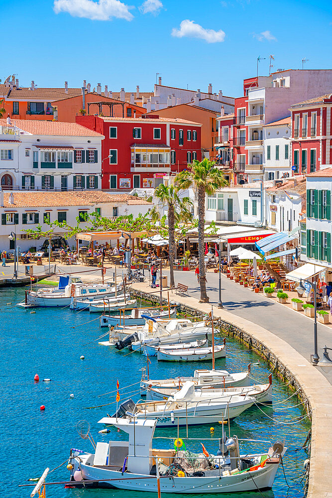 View of colourful cafes, restaurants and boats in harbour against blue sky, Cales Fonts, Menorca, Balearic Islands, Spain, Mediterranean, Europe