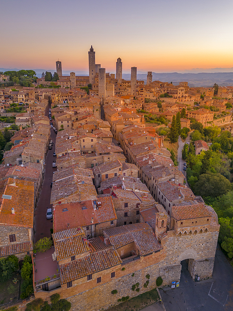 Elevated view of rooftops and town at sunrise, San Gimignano, Tuscany, Italy, Europe