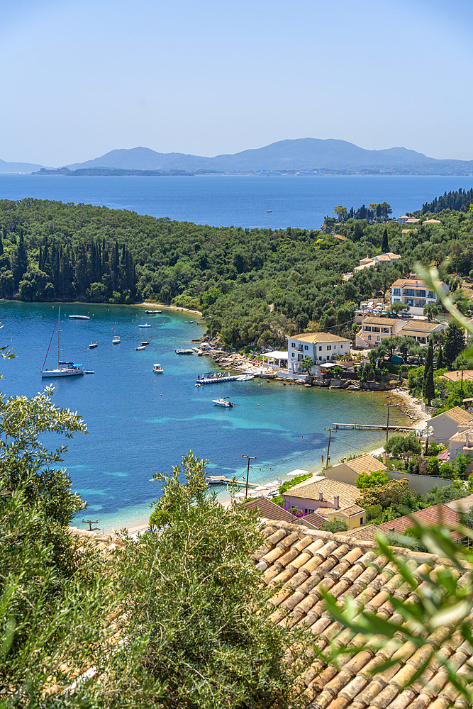 View of boats in the bay at Kalami with Corfu Town in background, Corfu, Ionian Sea, Greek Islands, Greece, Europe