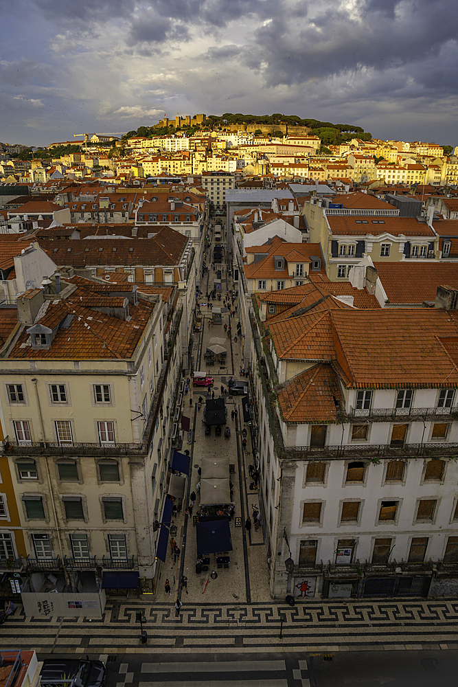 View of city rooftops and Lisbon Castle from Santa Justa Lift during golden hour, Lisbon, Portugal, Europe