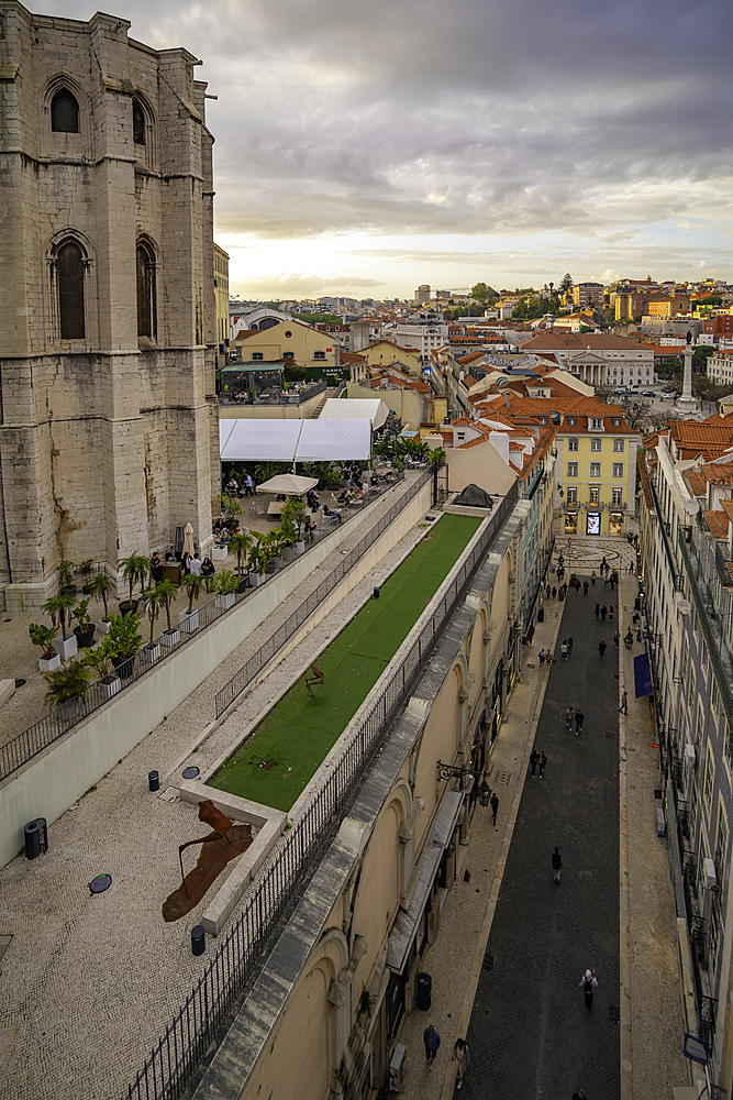 View of city rooftops and Carmo Archaeological Museum from Santa Justa Lift during golden hour, Lisbon, Portugal, Europe
