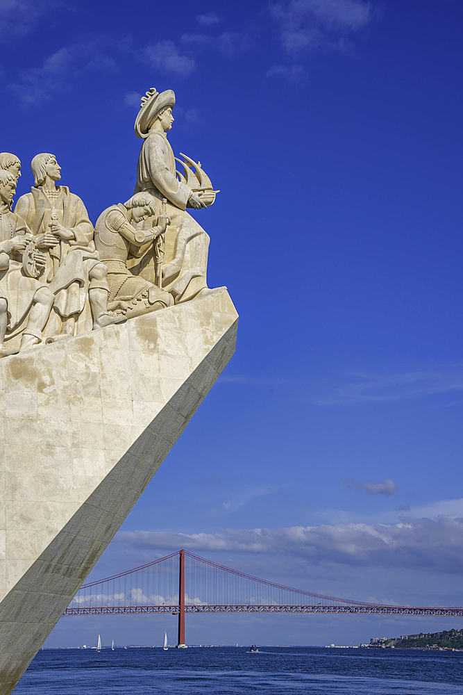 View of Monument to the Discoveries (Padrão dos Descobrimentos) and 25 April Bridge on a sunny day, Lisbon, Portugal, Europe