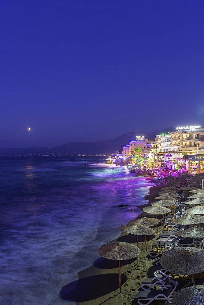 View of beach and town overlooking the sea in Limenas Chersonisou at dusk, Crete, Greek Islands, Greece, Europe