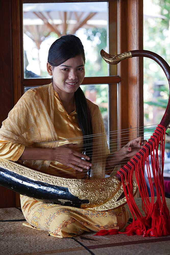 Girl playing traditional saung gauq (boat shaped harp) at Popa Mountain Resort, Mount Popa, near Bagan, Central Myanmar, Myanmar (Burma), Asia