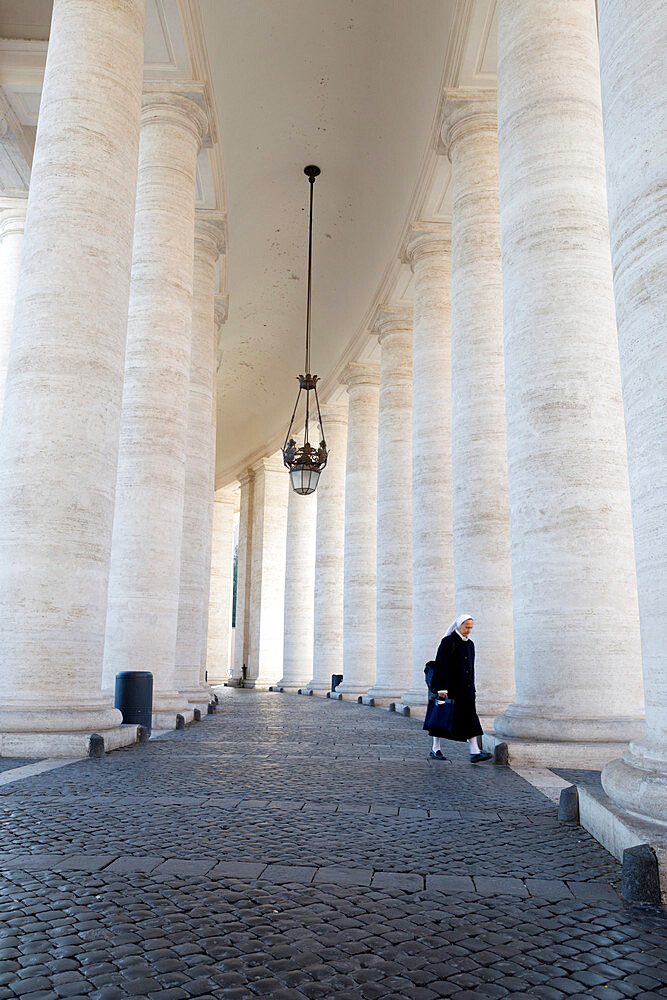 The colonnades and nun in St. Peter's Square (Piazza San Pietro), Vatican City, Rome, Lazio, Italy, Europe