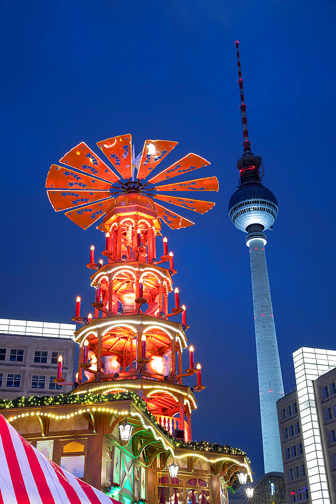 Christmas Pyramid at Christmas market in Alexanderplatz with Fernsehturm television tower behind, Berlin-Mitte, Berlin, Germany, Europe