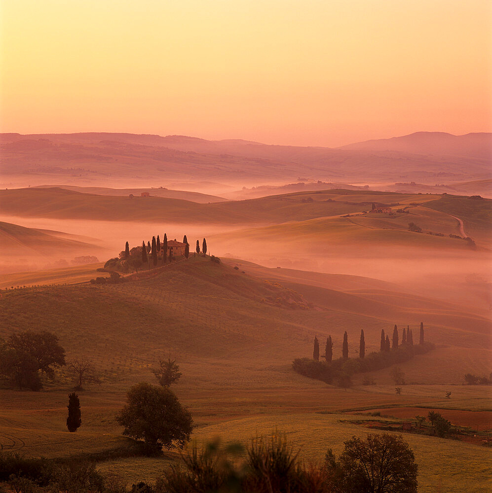 Tuscan farmhouse with cypress trees in misty landscape at sunrise, San Quirico d'Orcia, Siena Province, Tuscany, Italy, Europe