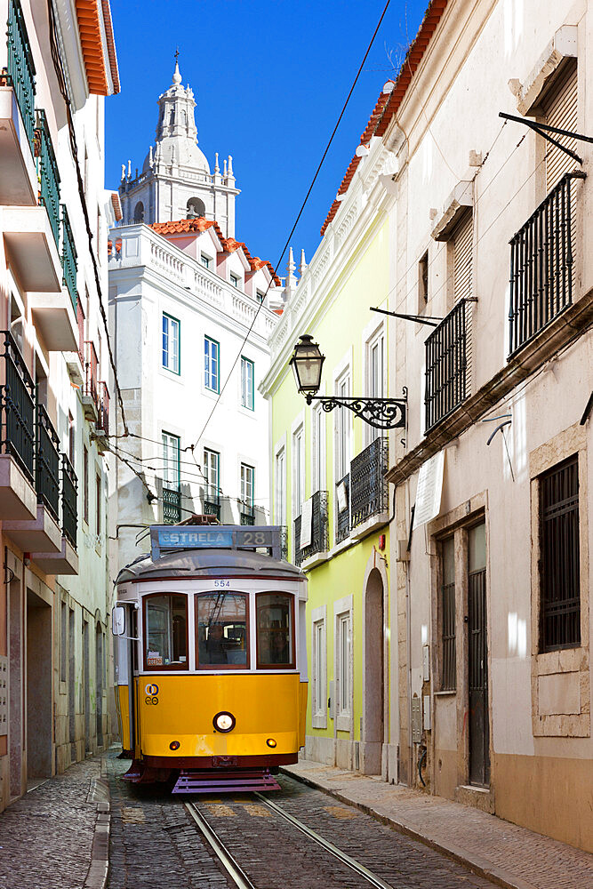 Tram (electricos) along Rua das Escolas Gerais with tower of Sao Vicente de Fora, Lisbon, Portugal, Europe