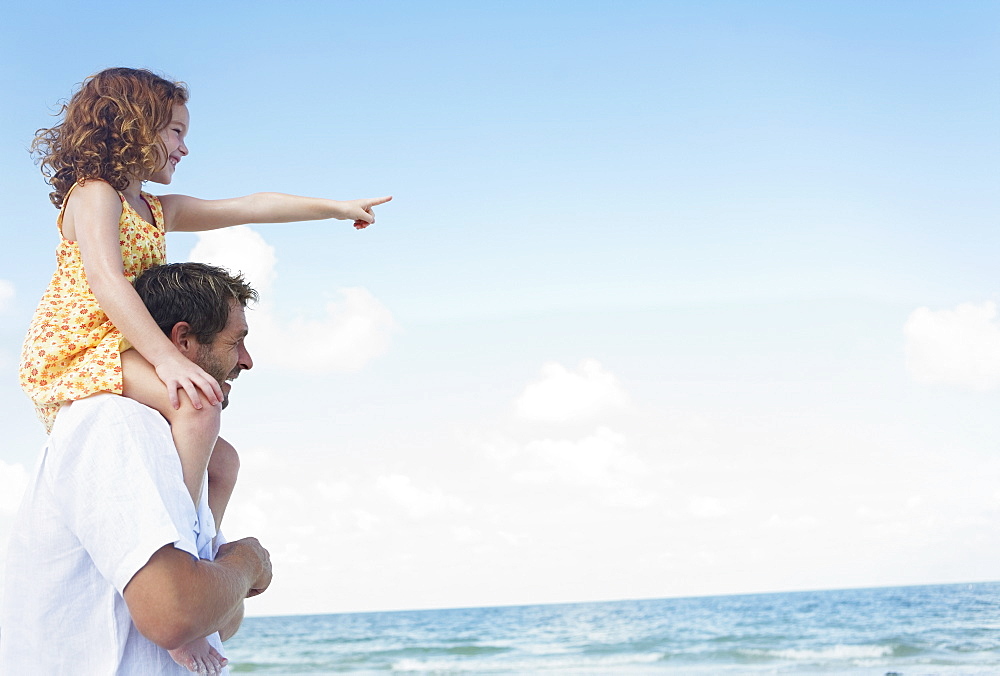 Father carrying daughter on shoulders