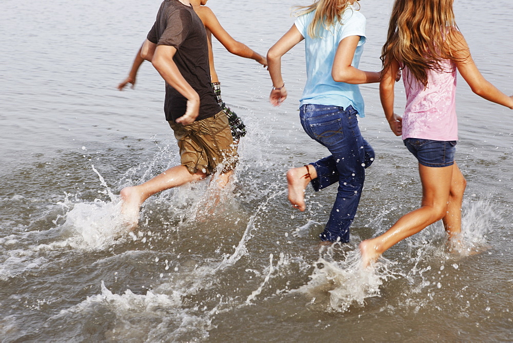 Children running in ocean