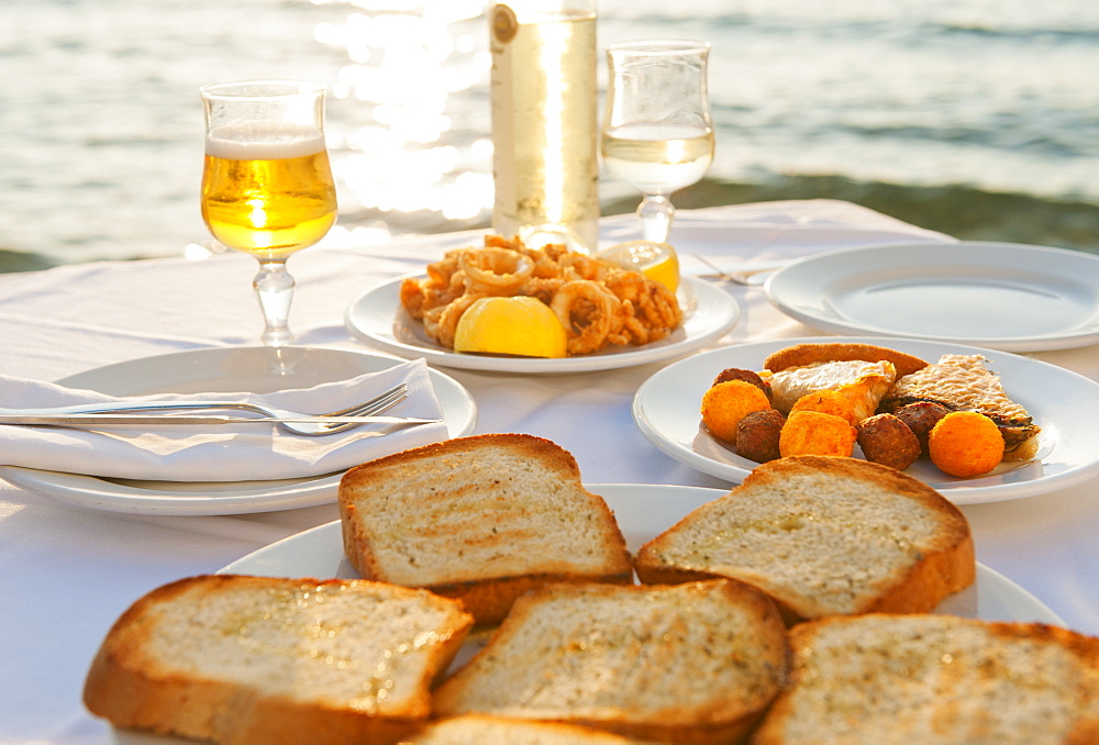 Greece, Cyclades Islands, Mykonos, Calamari appetizer on set table by sea