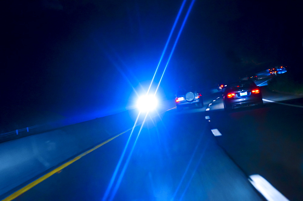 Car headlights on road at night