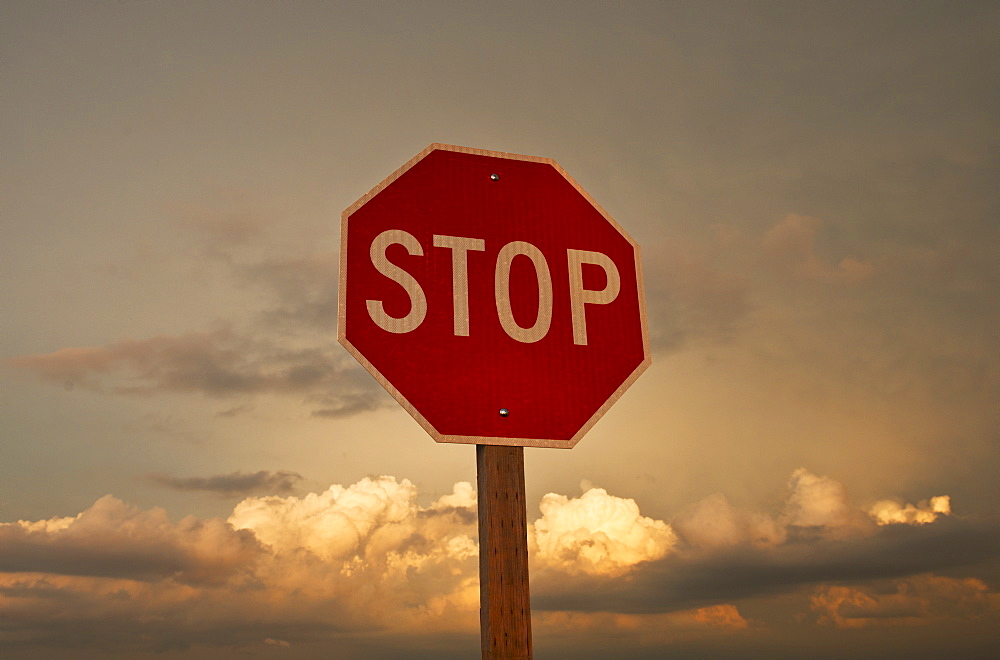 USA, South Dakota, Badlands National Park, Stop sign against sky at sunset