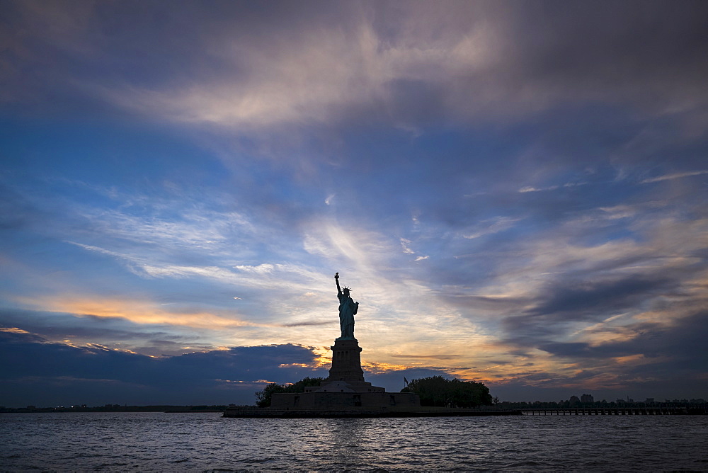 Silhouette of Statue of Liberty at sunset, New York City, New York