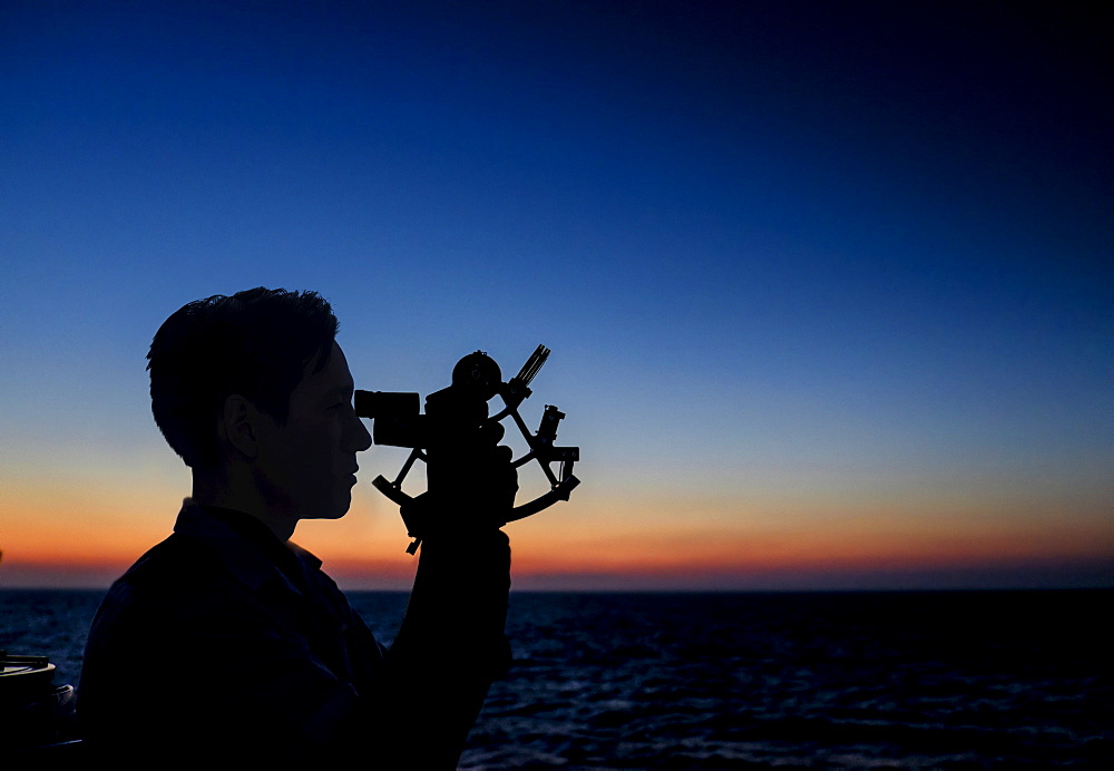Man looking through sextant