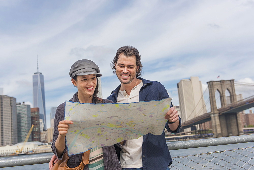 Happy couple reading map, Brooklyn, New York