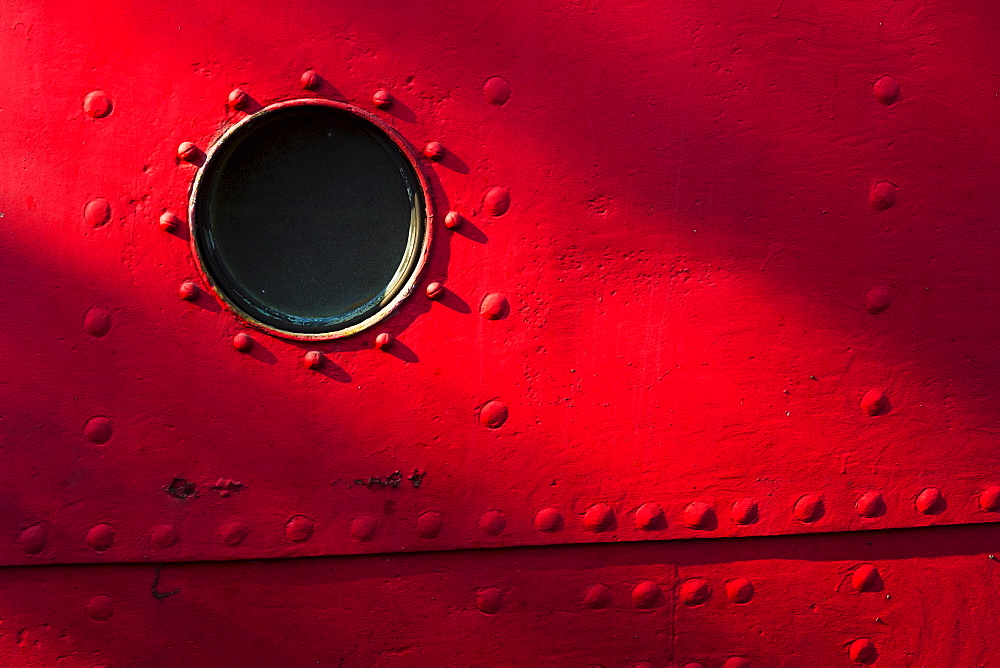Porthole of red nautical vessel