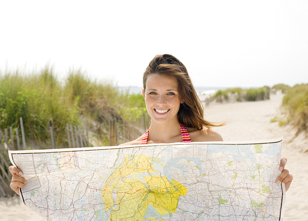 Woman holding map at beach