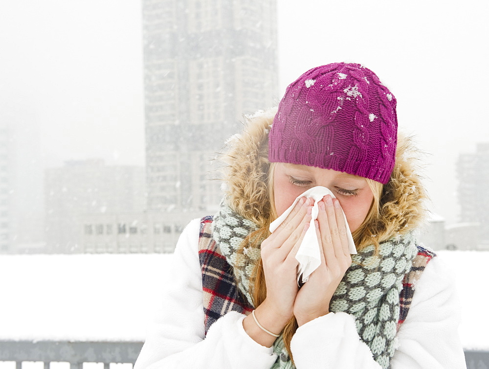 USA, New Jersey, Jersey City, woman blowing nose