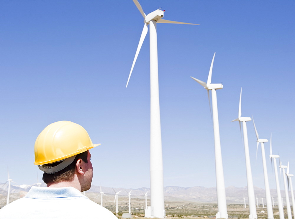 USA, California, Palm Springs, Coachella Valley, San Gorgonio Pass, Man in hard hat looking at wind turbines