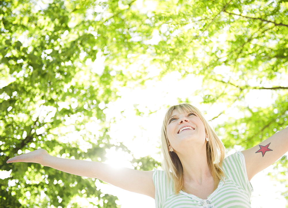 USA, New York, Williamsburg, Brooklyn, Portrait of smiling woman under green tree