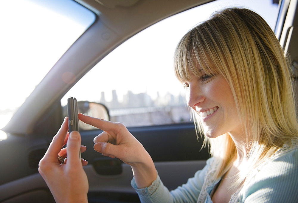 USA, Brooklyn, Williamsburg, Woman using smart phone in car