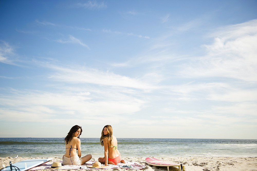 Two women relaxing on beach, Rockaway Beach, New York