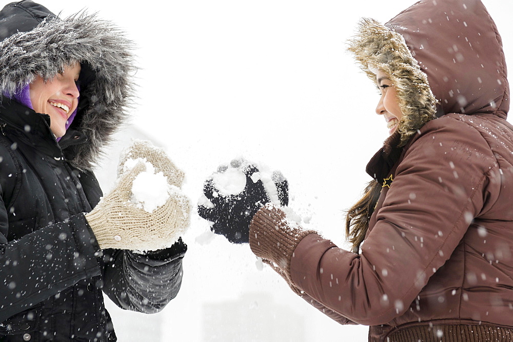 Two young women having snowball flight