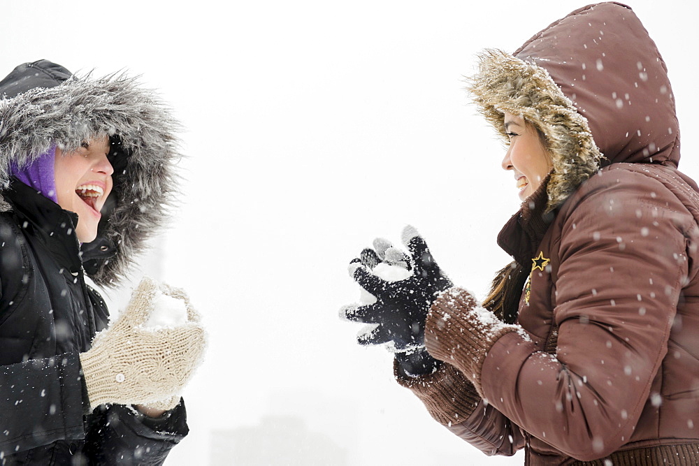 Two young women having snowball flight
