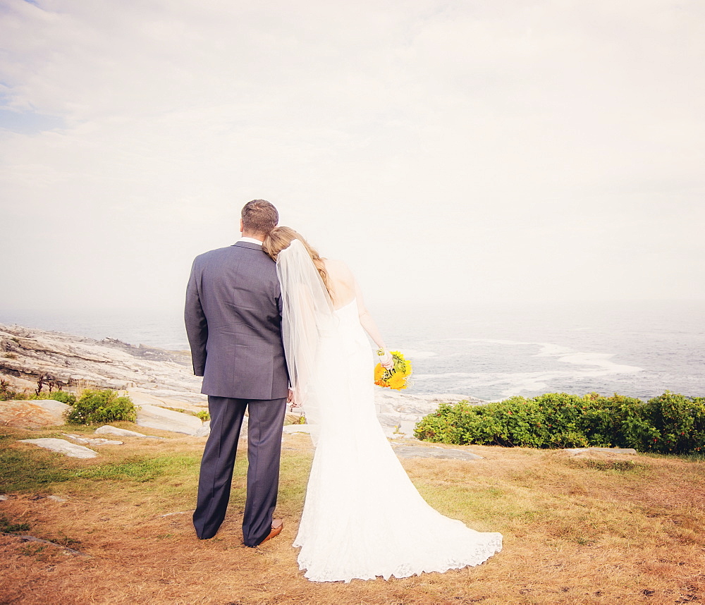 Rear view of married couple standing by sea, USA, Maine, Bristol 