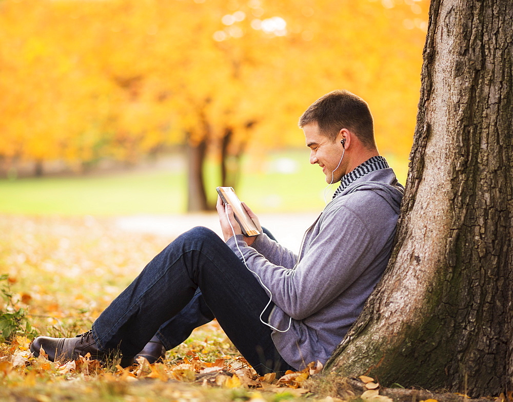 Young man using digital tablet in Central Park, USA, New York State, New York City