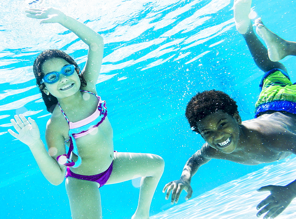 Girl and boy ( 6-7, 8-9) swimming